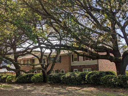 A large brick house with trees in front of it

Description automatically generated with low confidence